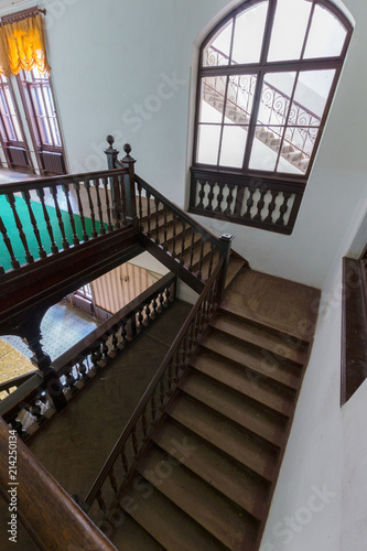 Vintage antique wooden staircase with beautiful decorative railing and large spans