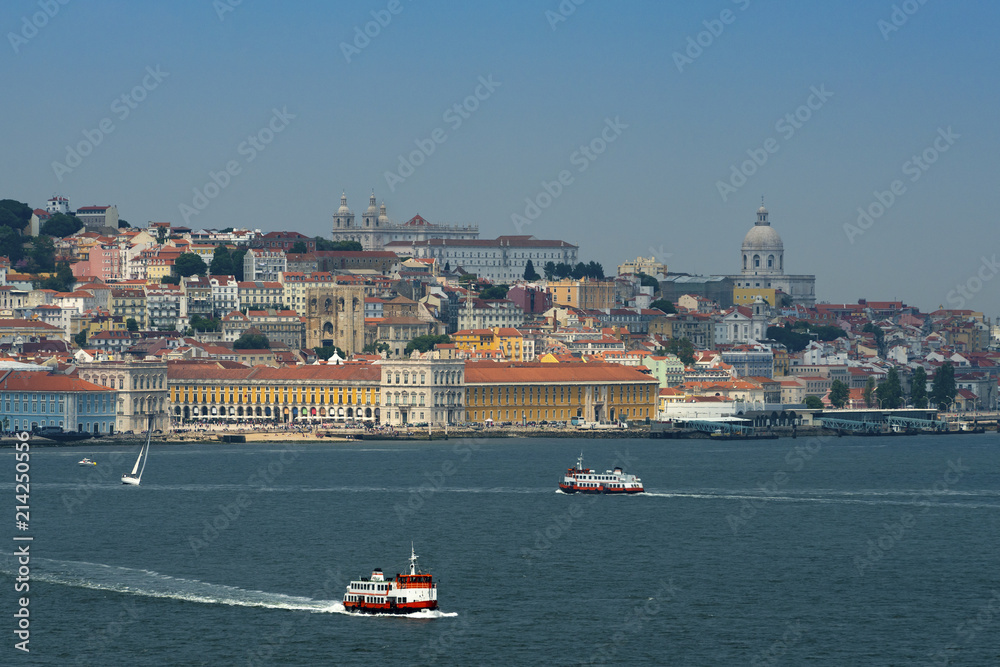 Obraz premium View of the skyline of the city of Lisbon with boats (cacilheiro) on the Tagus River; Concept for travel in Portugal and visit Lisbon