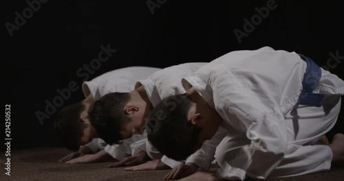 Three karate practitioners bowing seiza