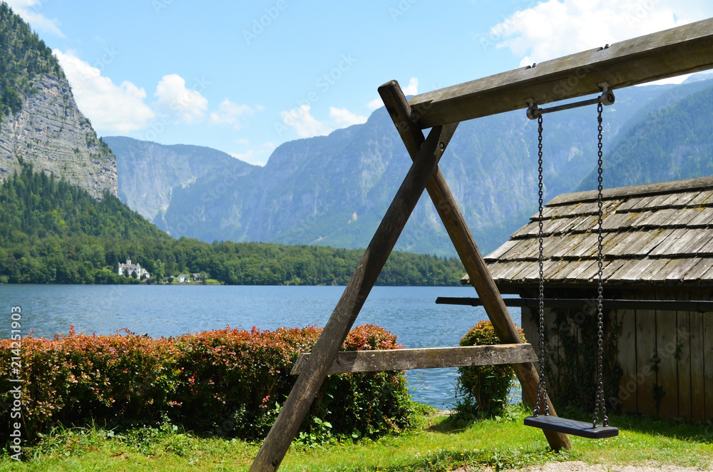Wooden swing and small house on picturesque riverbank Wooden swing and small house on picturesque riverbank