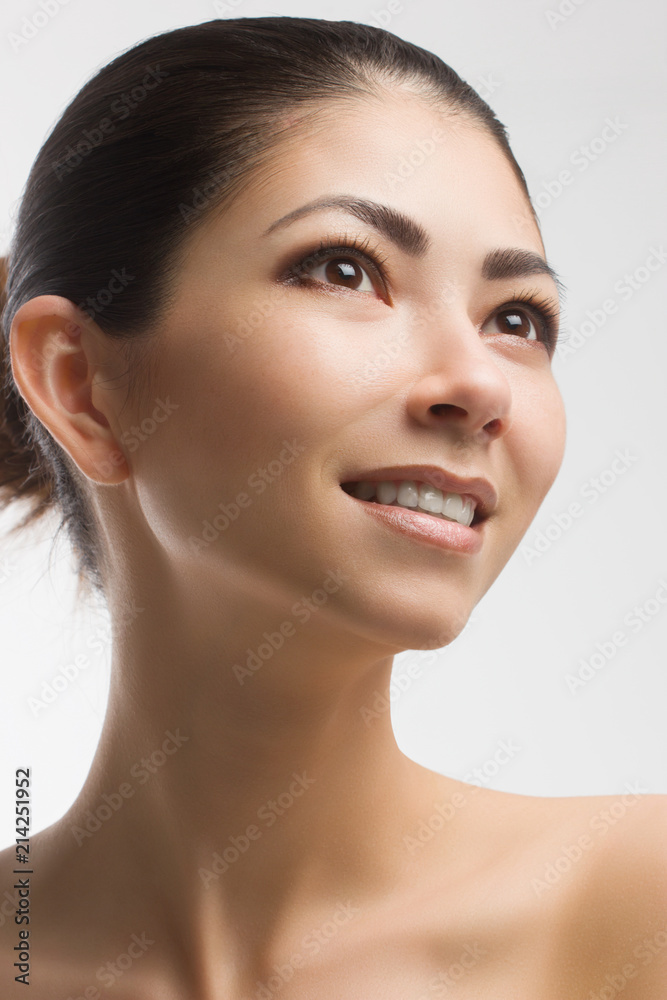 The beautiful brunette with clean smooth skin smiles with an open mouth. it is isolated on a white background. Cosmetology and Spa salon. Fashionable picture. Evening Cosmetics. Long neck. The beautiful brunette with clean smooth skin smiles with an open mouth. it is isolated on a white background. Cosmetology and Spa salon. Fashionable picture. Evening Cosmetics. Long neck.