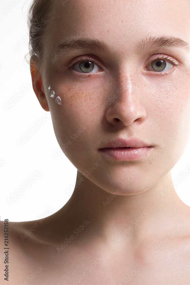 Fototapeta premium The beautiful young woman the blonde with an ideal thin skin and natural cosmetics. Cream on a face. Cosmetology, Spa procedures. Purity and grace.
