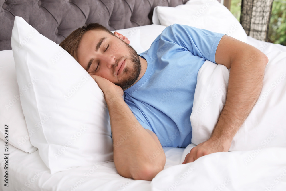 Young handsome man sleeping in bed at home. Early morning Young handsome man sleeping in bed at home. Early morning