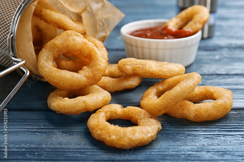 Onion rings served on wooden table, closeup