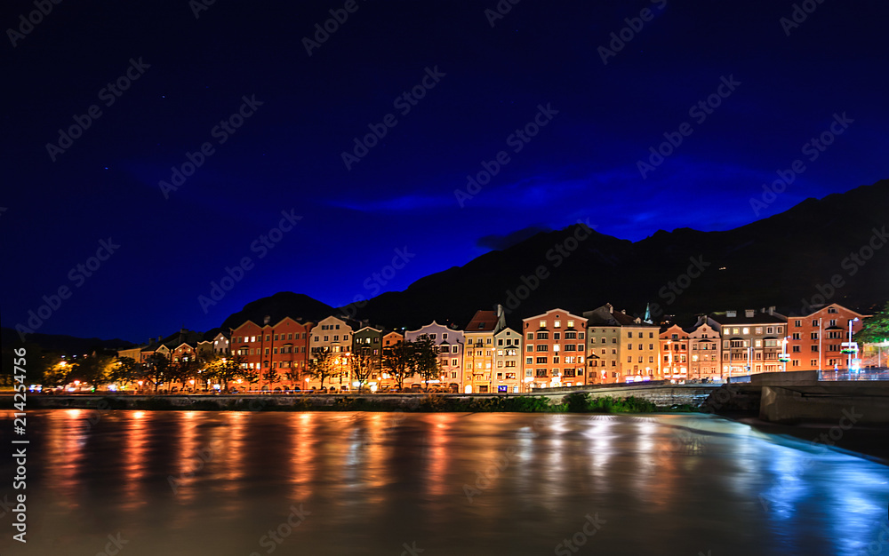 Night view of Charming Innsbruck architectural houses on Inn River and European alps natural background, Tyrol, Austria, Europe