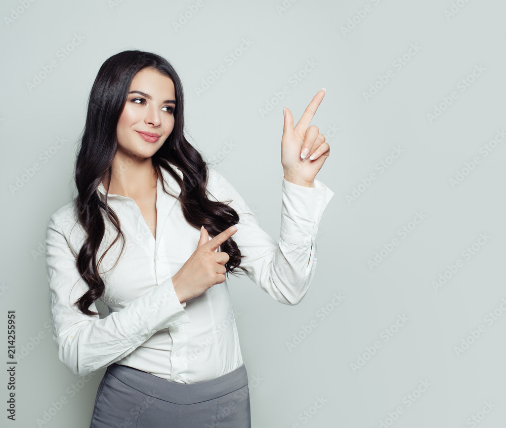Beautiful business woman pointing her finger up. Student girl showing empty copy space for advertising marketing or product placement. Business, seo or education concept Beautiful business woman pointing her finger up. Student girl showing empty copy space for advertising marketing or product placement. Business, seo or education concept