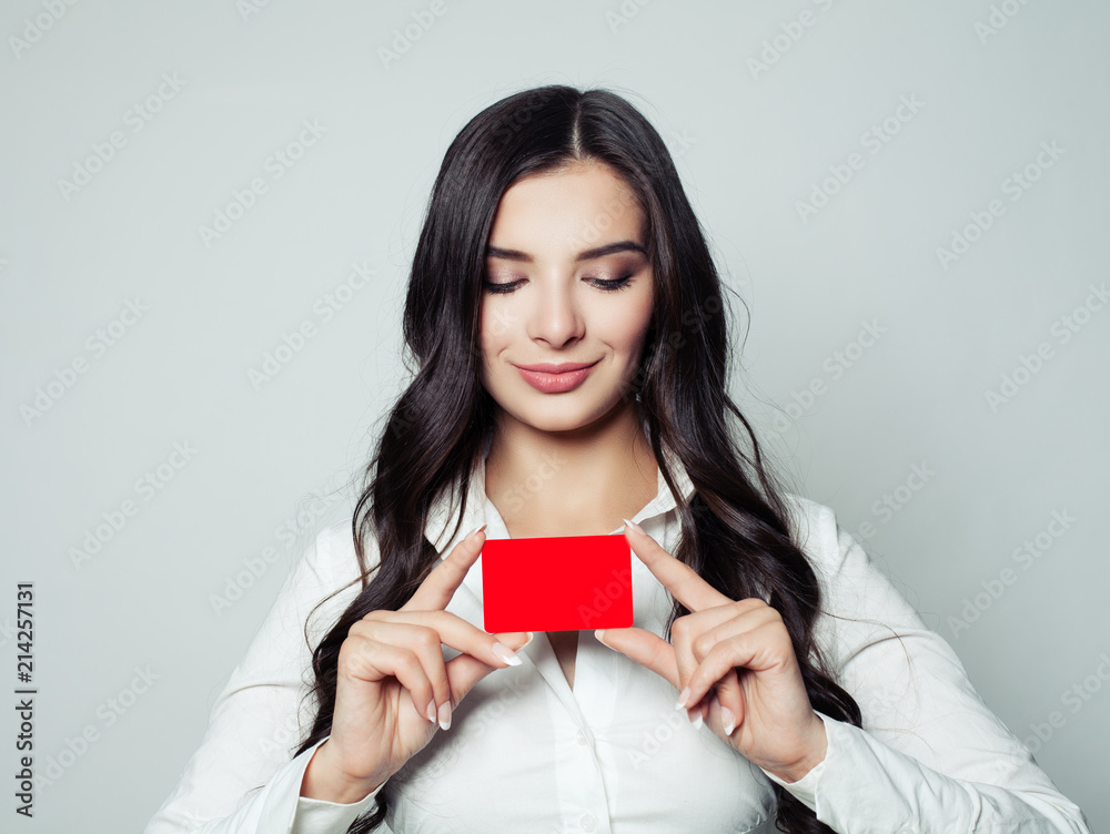 Happy business woman with red empty card. Young woman smiling and holding blank card in her hands, business and education concept Happy business woman with red empty card. Young woman smiling and holding blank card in her hands, business and education concept