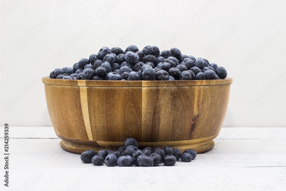 Close up of a wooden bowl full of farm fresh blueberries Close up of a wooden bowl full of farm fresh blueberries