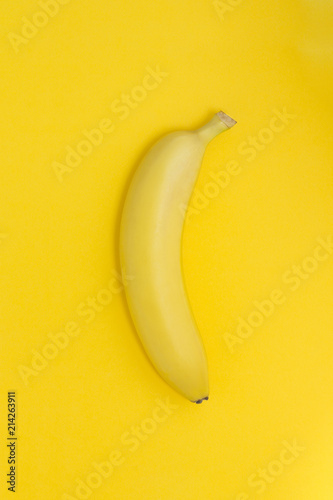 Creative view of a banana on a paper yellow background.
