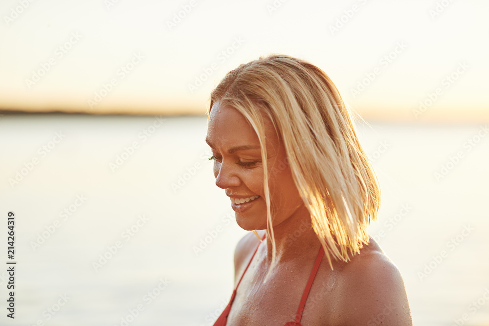 Smiling young blonde woman enjoying a day at the beach