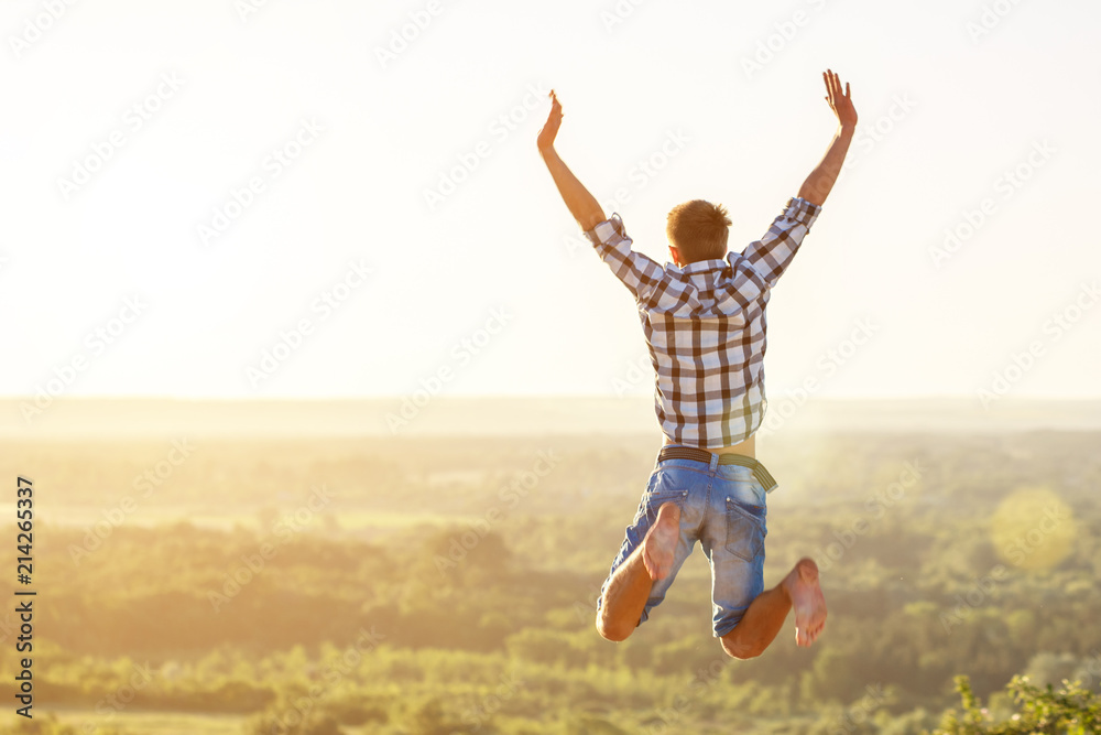 happy guy jumping to the top on the background of nature and sun concept of success and happiness happy guy jumping to the top on the background of nature and sun concept of success and happiness