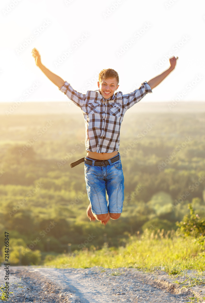 happy guy jumping to the top on the background of nature and sun concept of success and happiness happy guy jumping to the top on the background of nature and sun concept of success and happiness