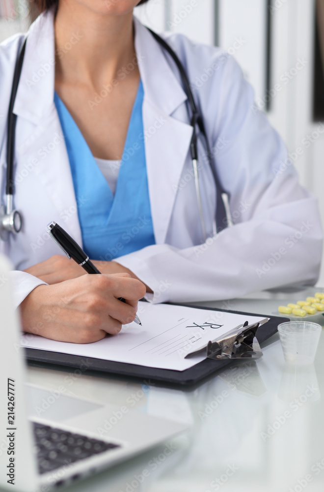 Doctor woman filling up prescription, close-up of hands. Physician at work. Medicine and healthcare concept Doctor woman filling up prescription, close-up of hands. Physician at work. Medicine and healthcare concept