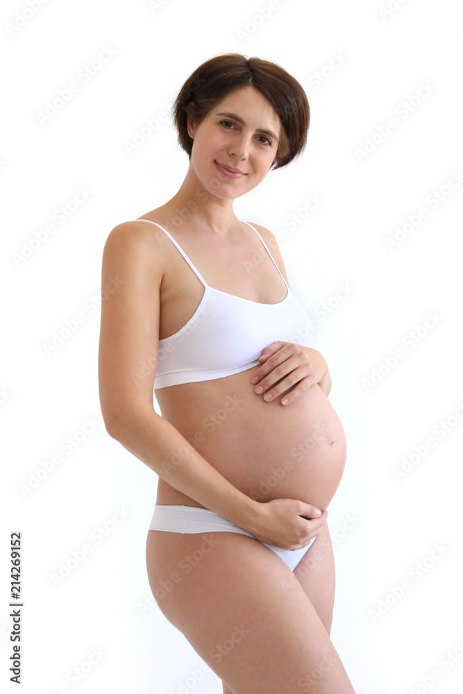 Hübsche schwangere Frau in weißer Unterwäsche hält sich lächelnd ihren  Bauch Stock-Foto | Adobe Stock