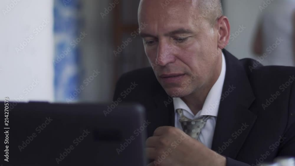 The man at the laptop straightens his tie The man at the laptop straightens his tie
