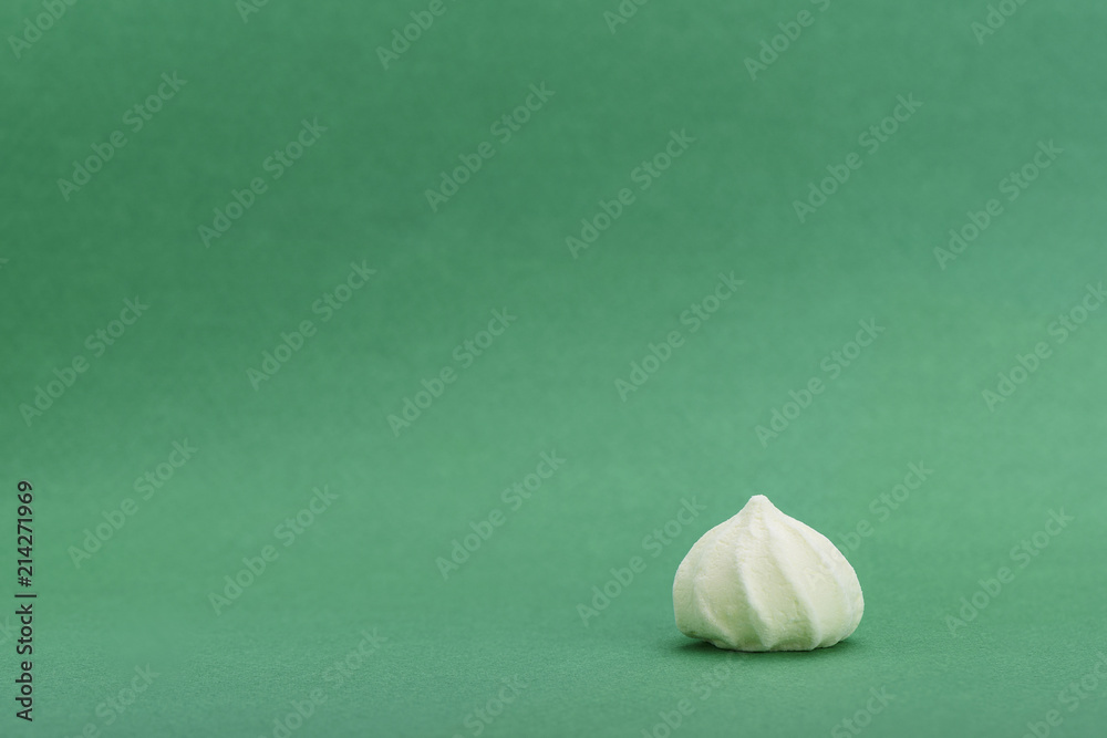 Yellow meringue isolated on green background with space for text