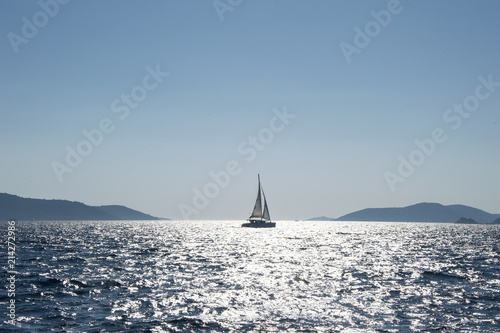 Sailboat between misty islands in Croatia. Sailing among the many beautiful islands of Croatia. Hvar, Brac, Vis, Korčula. 