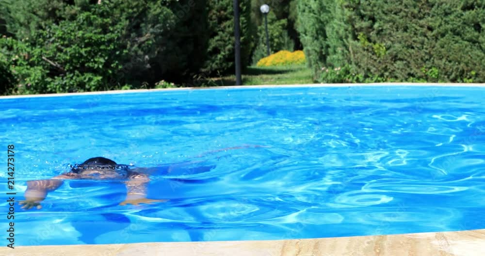 Young boy in swimming pool smiling to a camera and showing thumbs up gesture Young boy in swimming pool smiling to a camera and showing thumbs up gesture