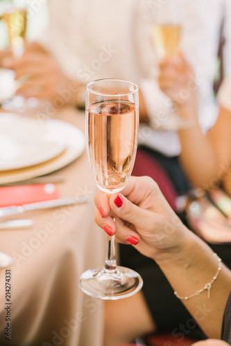 woman holds glass of champaigne. Focus on wine glass