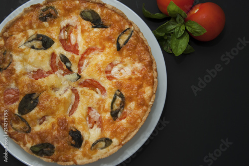 Quiche Tart Pie with Tomatoe, ,Spinach, Cheese. Foods and Pastries. Isoalted, Black Background. Top View.
