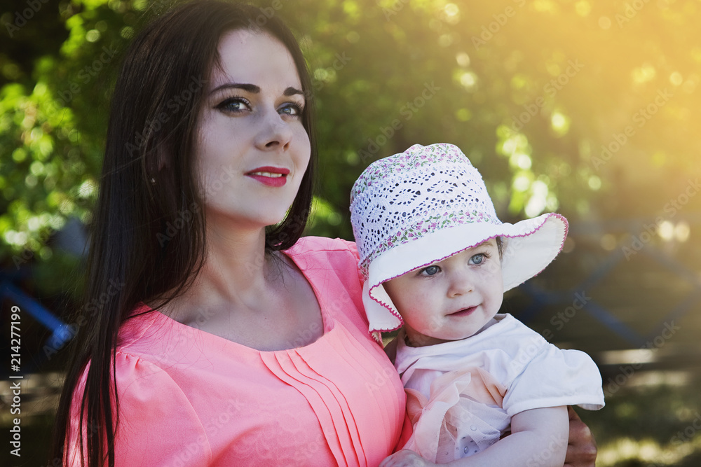 Obraz premium Mom and daughter on the background of the garden