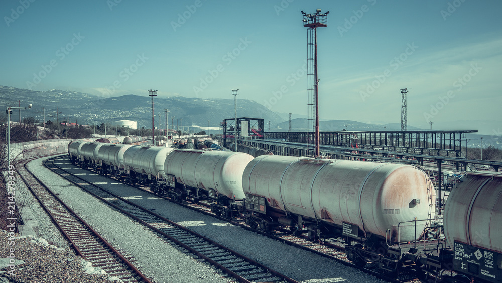 Panoramic view of train station in the gray industrial zone with wagons on the rail trail.
