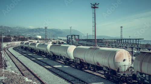 Obraz na płótnie Panoramic view of train station in the gray industrial zone with wagons on the rail trail. w salonie