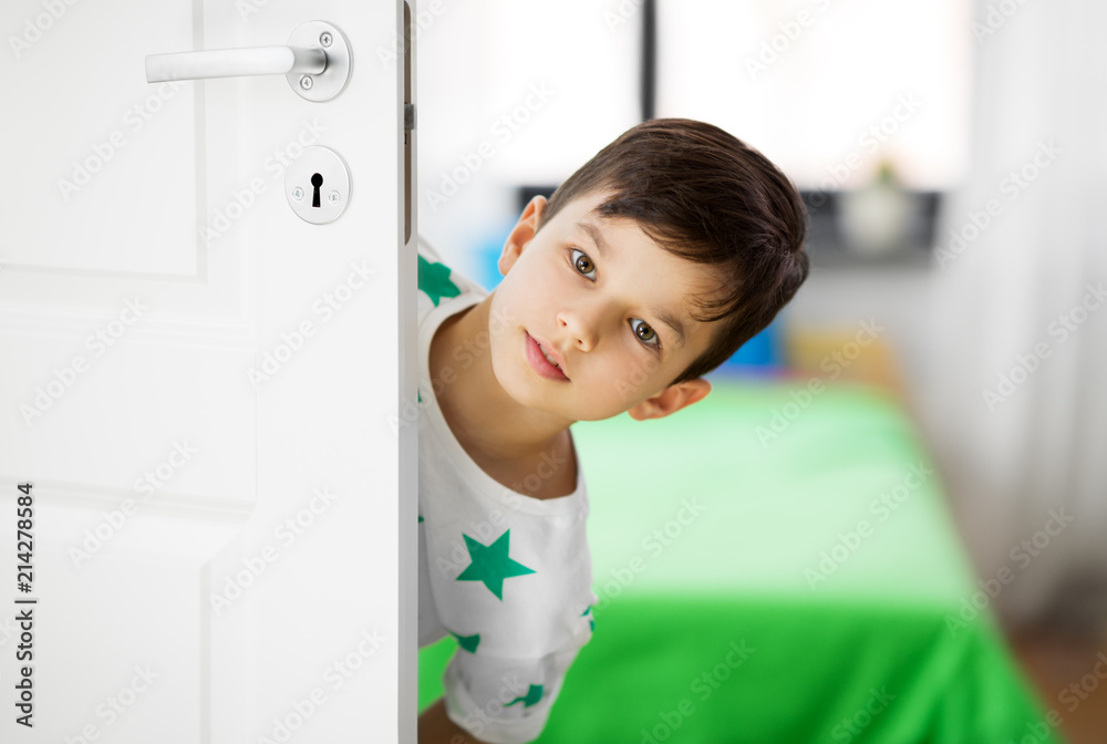 childhood, fun and people concept - little boy behind door at home childhood, fun and people concept - little boy behind door at home