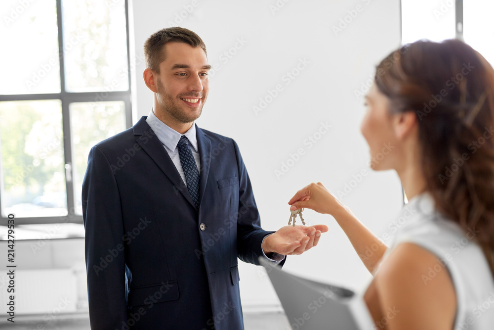 real estate business, sale and people concept - realtor giving key to customer or new office owner real estate business, sale and people concept - realtor giving key to customer or new office owner