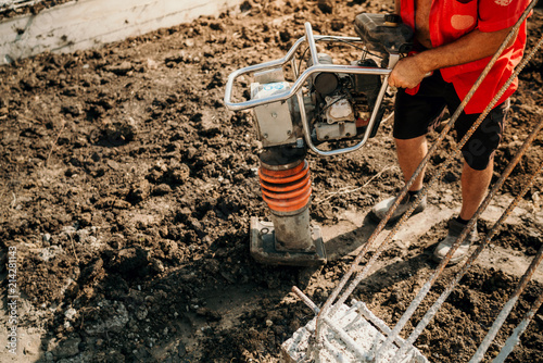 Wallpaper Mural Details of construction worker using compactor for earth and soil compacting Torontodigital.ca