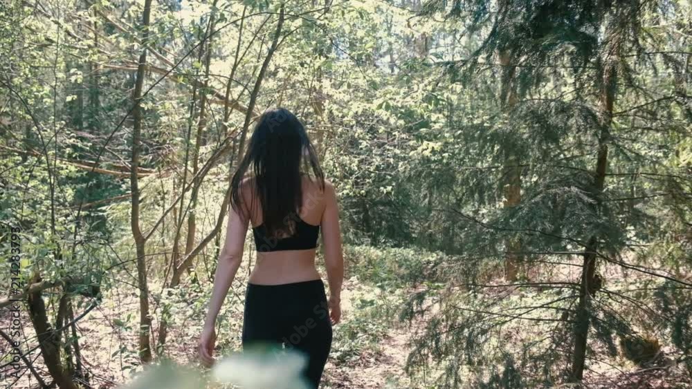 Woman in sportswear is hiking in the forest. Slow motion. Woman in sportswear is hiking in the forest. Slow motion.