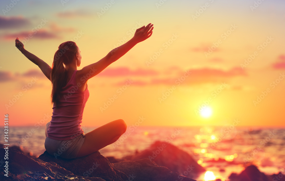 Naklejka premium Relaxation And Yoga At Sunset - Girl With Open Arms Looking Ocean 