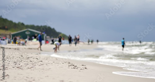 Unrecognizable people resting on the beach of Baltic Sea.