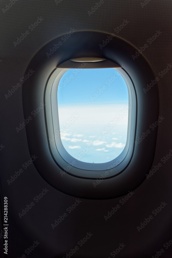 Looking at window in airplane to cloudy sky and horizon, traveling by flight Looking at window in airplane to cloudy sky and horizon, traveling by flight
