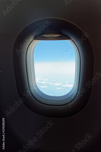 Looking at window in airplane to cloudy sky and horizon, traveling by flight
