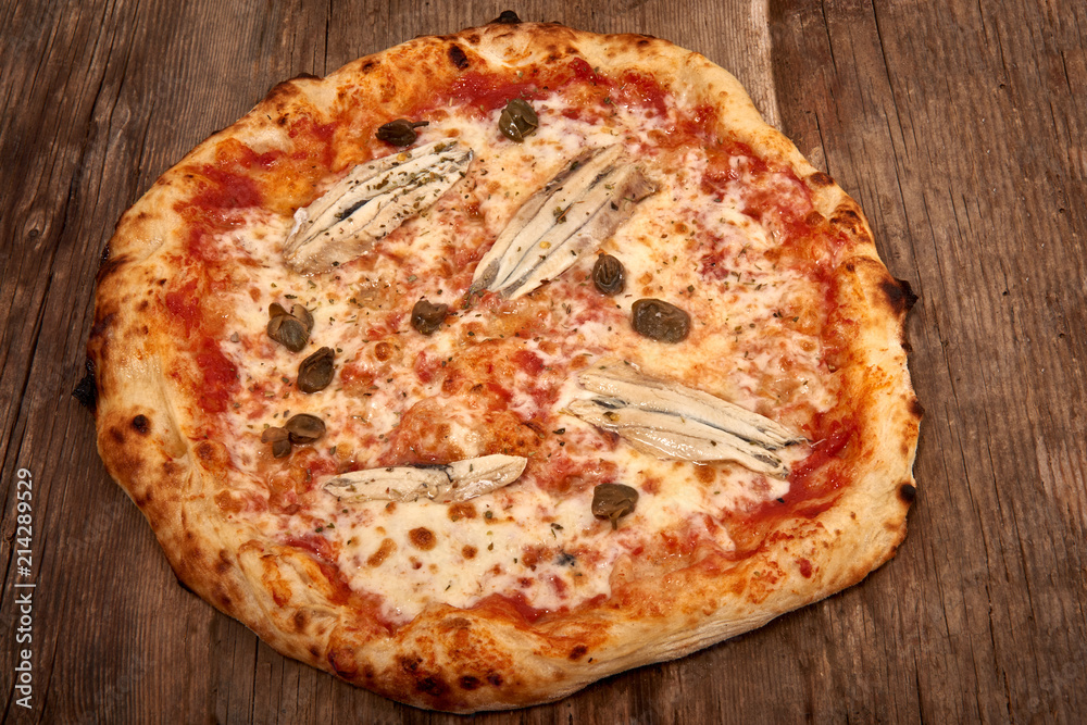 Homemade fresh delicious gourmet pizza,Tasty italian pizza isolated on wooden table, closeup