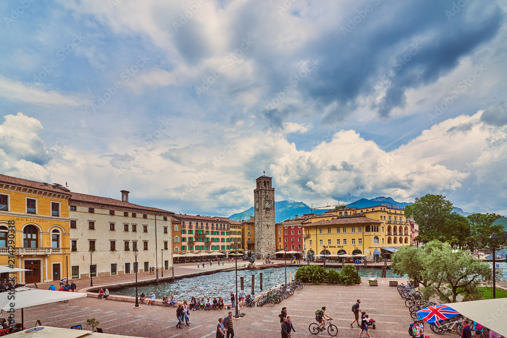 Obraz premium Riva del Garda,Lago di Garda ,Italy - 25 May 2018:View of the beautiful Riva del Garda town, Panorama of the gorgeous Garda lake surrounded by mountains in the in the spring on a stormy day