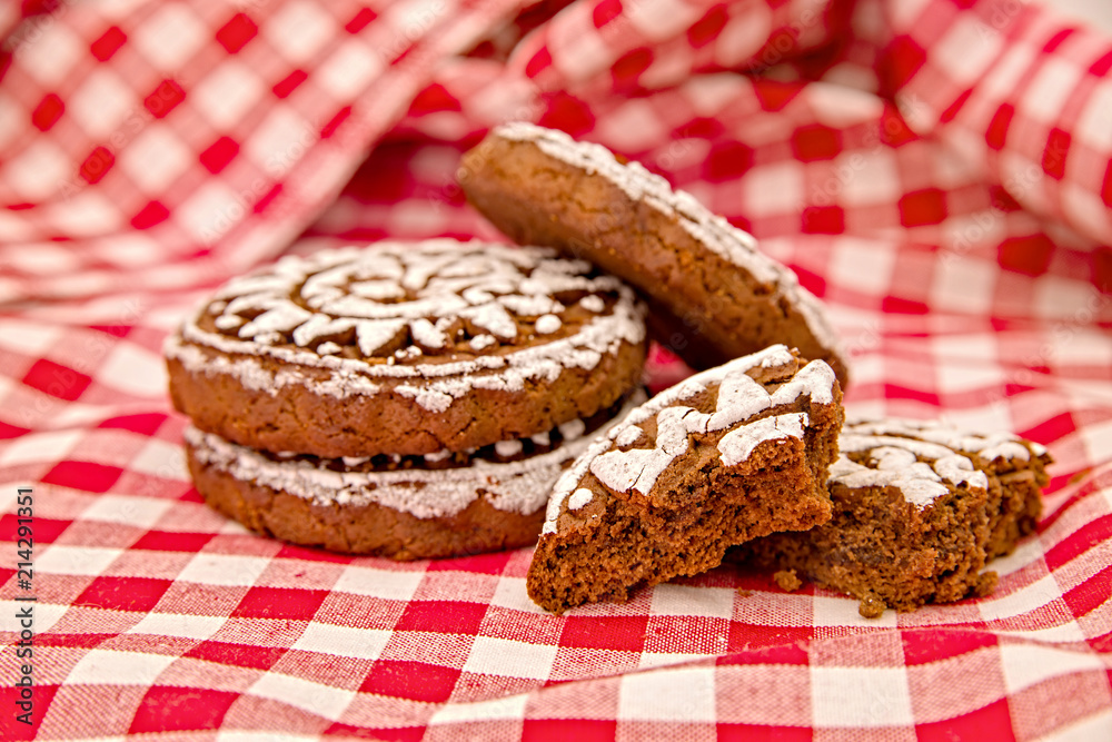 pile of gingerbreads with two broken pieces on red and white tradational tablecloth pile of gingerbreads with two broken pieces on red and white tradational tablecloth