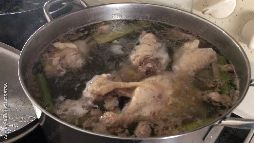 Pot of chicken soup boiling on the stove Pot of chicken soup boiling on the stove