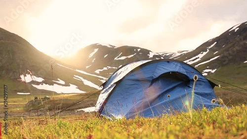Tent on grass in front of a mountin with snow during sunset. Located in northern Sweden. photo