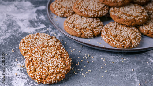 Oatmeal cookies with sesame seeds on a concrete background. © yusev