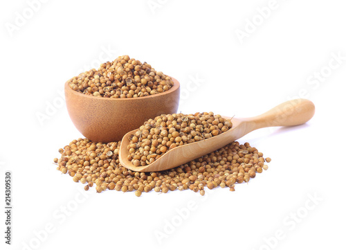 Split coriander seeds in wood cup and spoon isolate on a white background.