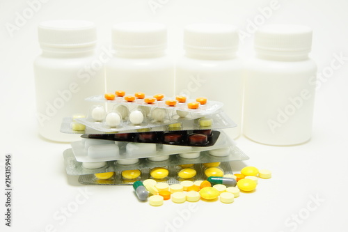 Obraz na plátně Medication. Tablets against white jars.