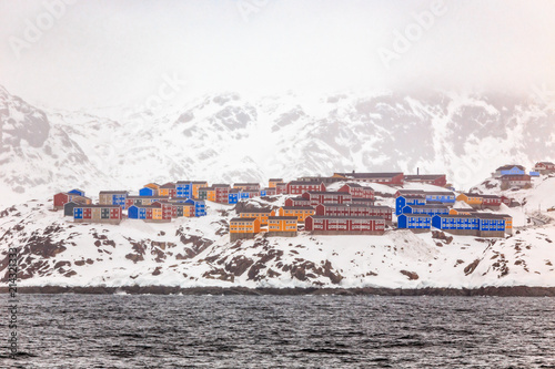 Rows of colorful Inuit living houses of Sisimiut, on the snow rocks, Greenland photo