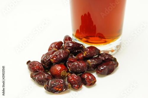 Dried berries of rosehip about a glass with infusion. photo