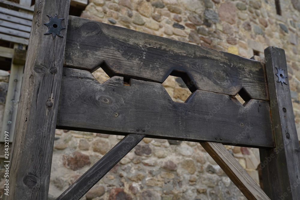 Empty wooden shackle for prisoners at a fortress yard Empty wooden shackle for prisoners at a fortress yard