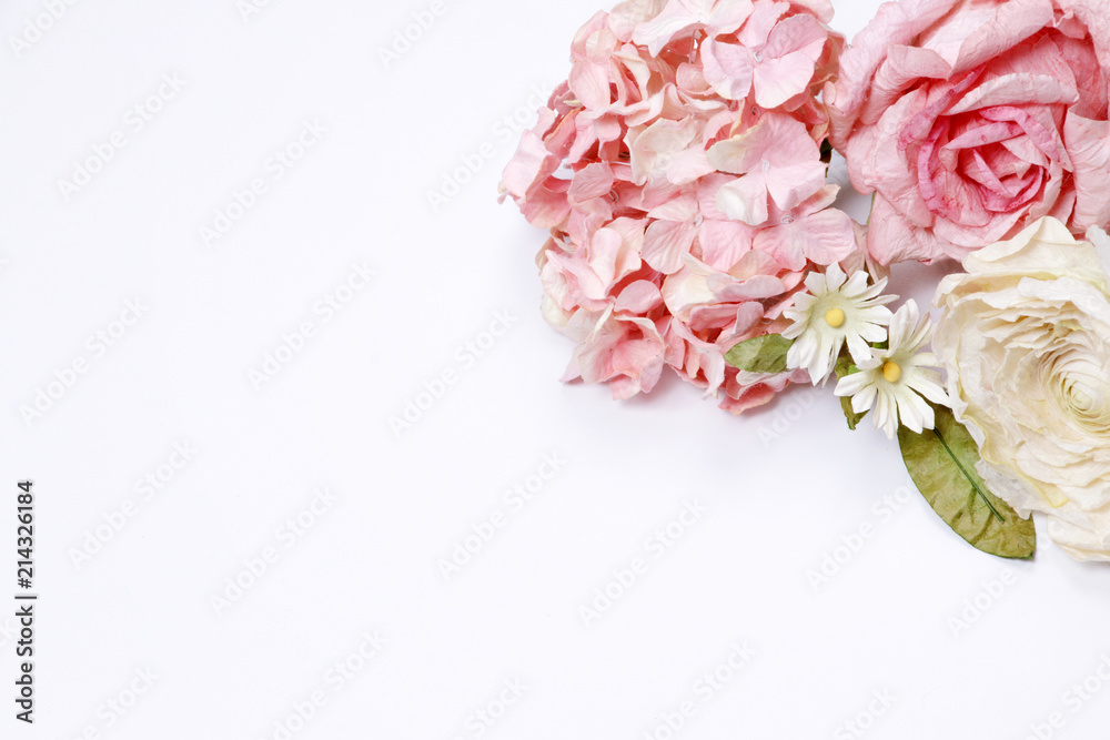 Frame made of pink and beige roses, green leaves, blue hydrangea, branches on white background. Flat lay, top view. Wedding's background. Valentine's background with copy space.