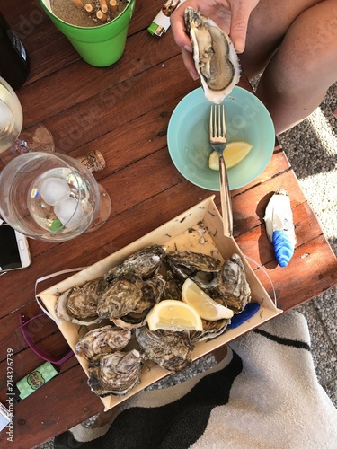 People enjoying a table laid with oysters, champagne and cigarettes. Hands closeup