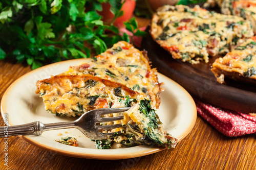 Portion of frittata made of eggs, mushrooms and spinach