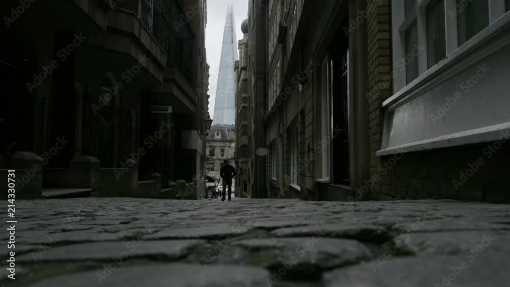 mysterious man walking cobblestone street between buildings alley Shard London mysterious man walking cobblestone street between buildings alley Shard London